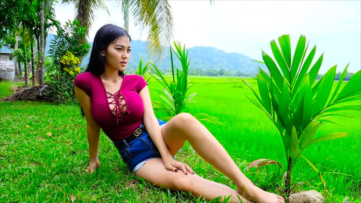 A buxom Thai woman near rice field
