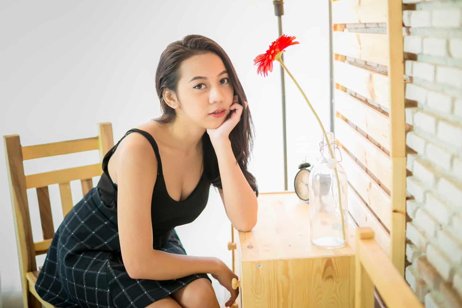 pretty thai girl with flower sitting near table