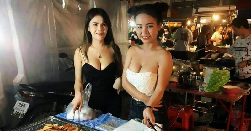 2 Thai girls cooking food at market
