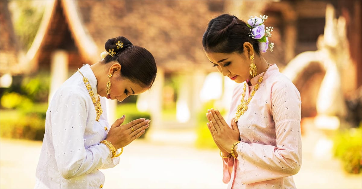 two gentle loving Thai women performing the wai