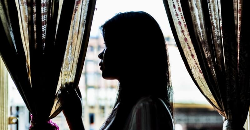Thai woman homesick staring out wondow